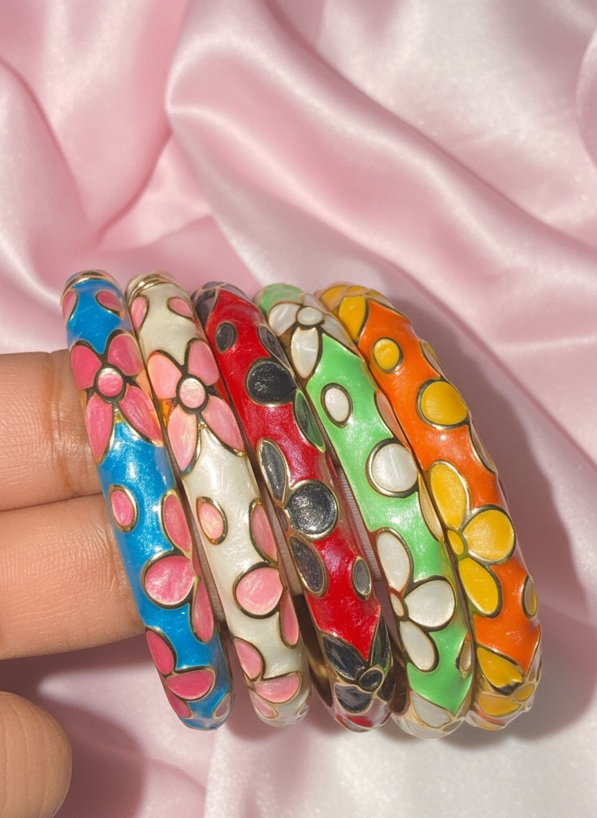 Wink & Wear Groovy Garden Stack featuring five colorful enamel bangle bracelets with floral patterns on satin fabric.